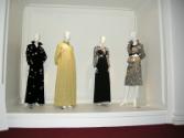 L to R: Black rhinestone belted Galanos dress, Gold brocade Galanos dress and coat worn to the …